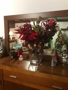 a vase of flowers on top of a dresser at O refugio do Mineiro in Arouca