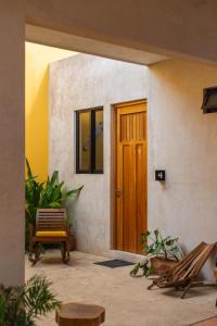 a front door of a house with chairs and a table at Hostik Hostal in Mérida