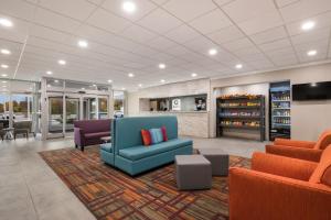 a lobby with a blue couch and two chairs at Clarion Hotel & Convention Center Joliet in Joliet