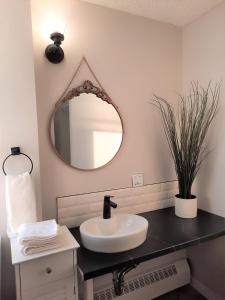 a bathroom with a sink and a mirror at Chic Studio Minutes to DT in Calgary