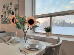 a dining room table with a vase of flowers on it at Chic Studio Minutes to DT in Calgary