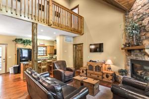 a living room with leather furniture and a stone fireplace at Branson Home with Game Room, Near Silver Dollar City in Branson