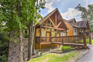 a log home with a large deck and trees at Branson Home with Game Room, Near Silver Dollar City in Branson
