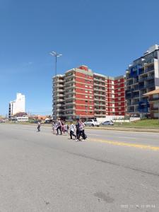 um grupo de pessoas ajoelhadas na beira de uma estrada em Departamento frente al Mar. em Mar del Plata