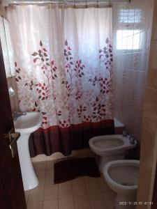 uma casa de banho com um WC e uma cortina de chuveiro em Departamento frente al Mar. em Mar del Plata