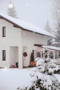 a snow covered house with a christmas wreath at GOOD DAYS Shale Resort 4 км до Буковеля in Yablunytsya