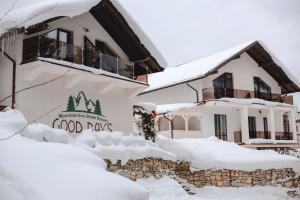 a house covered in snow with a sign that reads food days at GOOD DAYS Shale Resort 4 км до Буковеля in Yablunytsya