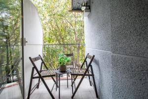a table and chairs on a balcony with a plant at 12TOG424 - Spacious Apartment near Camp Nou in Hospitalet de Llobregat