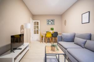 a living room with a blue couch and a table at 12TOG424 - Spacious Apartment near Camp Nou in Hospitalet de Llobregat