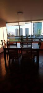 a dining room with a table and chairs and a window at Dpto frente a Cavancha 6P in Iquique
