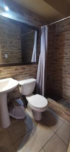 a bathroom with a toilet and a sink at Dpto frente a Cavancha 6P in Iquique