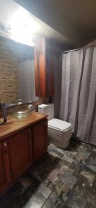 a bathroom with a white toilet and a sink at Dpto frente a Cavancha 6P in Iquique