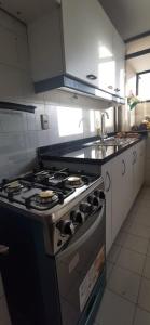 a kitchen with a stove and a sink at Dpto frente a Cavancha 6P in Iquique