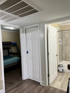 a room with a door and a bed and a bathroom at Trinity One Apartments - Country Luxury in Jackson