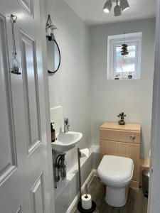 Baño blanco con aseo y lavamanos en Church View a first floor apartment in the heart of historic Topsham en Topsham