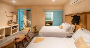 1 dormitorio con 2 camas y escalera en Bacalari - Adults Only en Bacalar