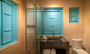 a bathroom with a sink and a glass shower at Bacalari Hotel Boutique in Bacalar