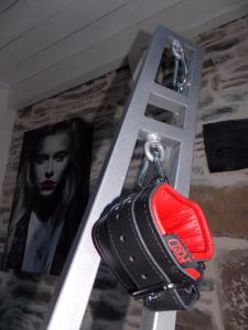 una bolsa negra y roja en un llavero junto a una foto en DOL' IN LOVE Love room BDSM 4 étoiles en Dol-de-Bretagne