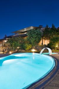 a large blue swimming pool in front of a building at Affittacamere S'Alzola in Porto Rotondo