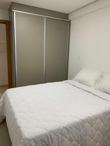1 dormitorio con 1 cama blanca grande y armario en Flat Atlântico Norte - Joao Pessoa a 200m del mar, en João Pessoa