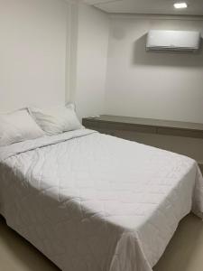 1 cama blanca en un dormitorio blanco con ventana en Flat Atlântico Norte - Joao Pessoa a 200m del mar, en João Pessoa