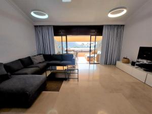 sala de estar con sofá negro y TV en Villa Happiness - Luxury chalet with sea view, en Las Palmas de Gran Canaria