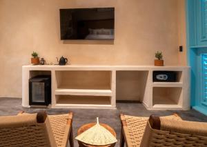 a living room with a tv and a table and chairs at Bacalari - Adults Only in Bacalar