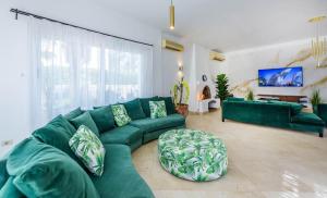 a living room with a green couch and a large window at Beautiful 4 bedroom White Villa with Heated Pool in Hurghada