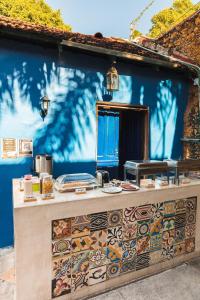 a blue wall with a counter with colorful tiles at Che Nomadas Mérida Hostel Adults Only in Mérida