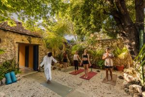a group of people doing yoga in front of a house at Che Nomadas Mérida Hostel Adults Only in Mérida