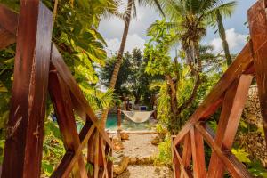 un cancello in legno che conduce a una piscina con palme di Che Nomadas Mérida Hostel Adults Only a Mérida