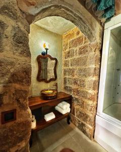 un bagno in pietra con lavandino e specchio di Fairouz Konak Otel a Mardin