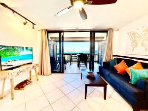uma sala de estar com um sofá azul e uma mesa em Sapphire Beachfront Renovated Villa 1200 SF! - Free Wi-Fi em East End