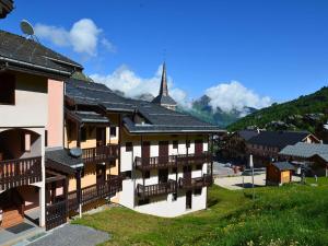 a building with balconies in a village with a church at Studio Saint-Martin-de-Belleville-Les Menuires, 1 pièce, 2 personnes - FR-1-452-319 in Saint-Martin-de-Belleville