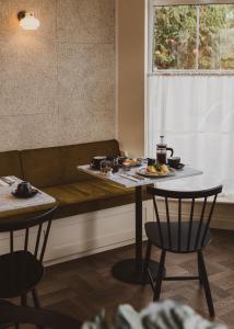 une table avec des assiettes de nourriture à côté d'un canapé dans l'établissement Leighton House - Boutique Guesthouse, à Bath