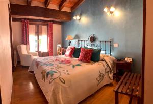 a bedroom with a large bed and a chair at Hotel Doña Sancha in Covarrubias