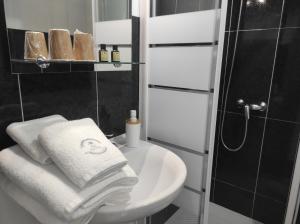 a bathroom with a sink and a shower and towels at Pensión NAVIA A Pontenova in A Pontenova