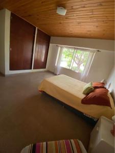 1 dormitorio con 2 camas y ventana en El Lirio Blan - Alquiler temporario en Capilla del Monte