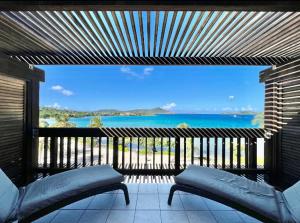 a view of the ocean from a balcony with a bench at Sapphire Beachfront Renovated Villa 1200 SF! - Free Wi-Fi in East End