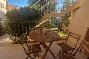 een houten tafel en stoelen met wijnglazen op een balkon bij Oásis do João e da Dalila in Portimão