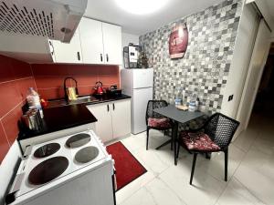 a kitchen with a stove and a table with chairs at Cute Penthouse in Marsaskala