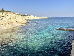 a large body of water next to a beach at Cute Penthouse in Marsaskala