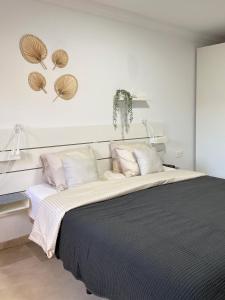 una camera con un letto bianco e nero con due lampade di Villa Happiness - Luxury chalet with sea view a Las Palmas de Gran Canaria