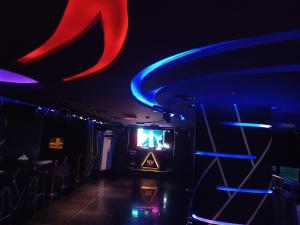 a dark room with a tv and neon lights at Al Qurum Resort in Muscat