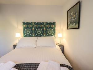 ein Schlafzimmer mit einem weißen Bett mit zwei Lampen in der Unterkunft Violet Cottage in Ambleside