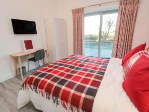 Schlafzimmer mit einem Bett, einem Schreibtisch und einem Fenster in der Unterkunft Clover Cottage in Newcastle upon Tyne