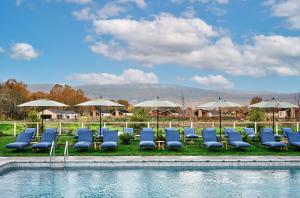 a group of chairs and umbrellas next to a pool at Wildflower Farms, Auberge Resorts Collection in Gardiner