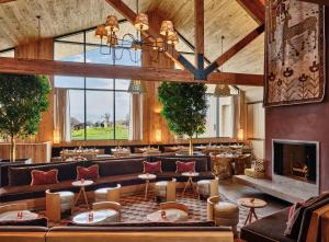 a large room with couches and tables and a fireplace at Wildflower Farms, Auberge Resorts Collection in Gardiner