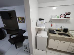 una pequeña cocina blanca con fregadero y escritorio en Israel Flat da Mar & Sol, en João Pessoa