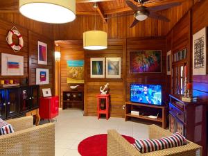 a living room with wooden walls and a flat screen tv at Bangalô de Madeira em Condomínio de Praia in Camaçari